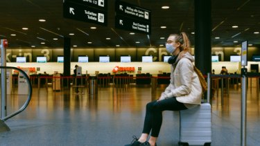 IAE25 blog image of a woman sitting on her luggage