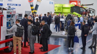 IAE25 press release image of attendees gathered at exhibition booths