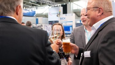 IAE image of show attendees toasting glasses